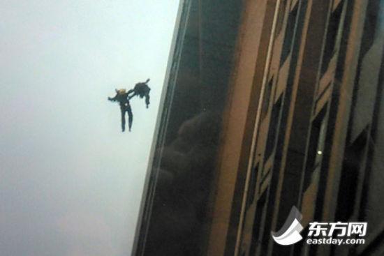 目擊者王先生用手機拍下兩位消防隊員墜樓時的畫面,圖上可以看出,兩消防員墜樓瞬間手拉著手